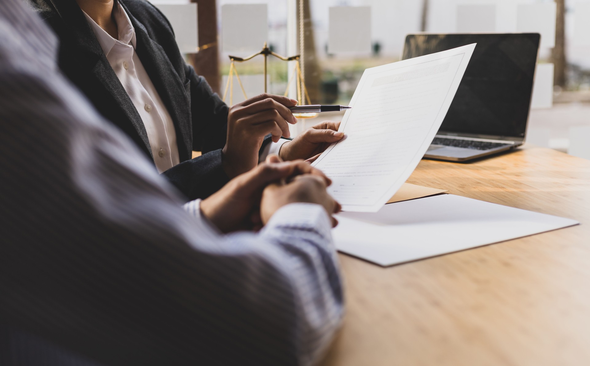 L’avocate explique les termes du document contractuel légal et demande au client de le signer correctement.